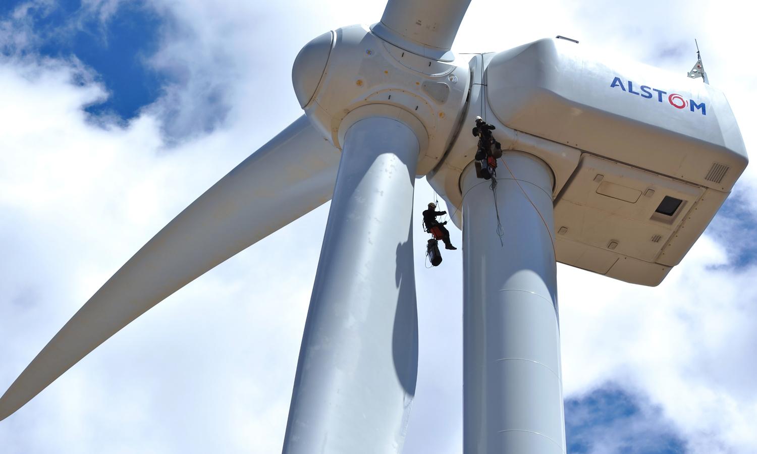 两个工人在一个风力涡轮机的顶部。